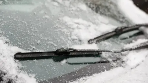 Car wiper blades clean snow from car windows (1)