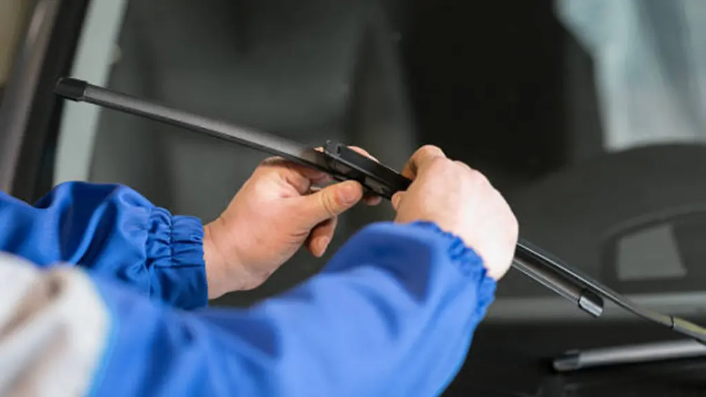 Technician is changing windscreen wipers on a car station